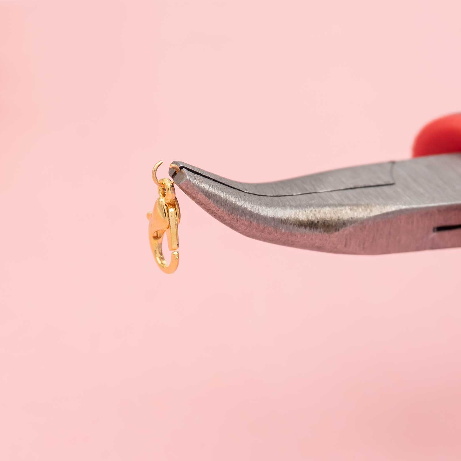goldfarbener Karabiner hängt in einem offenen Biegering Closeup