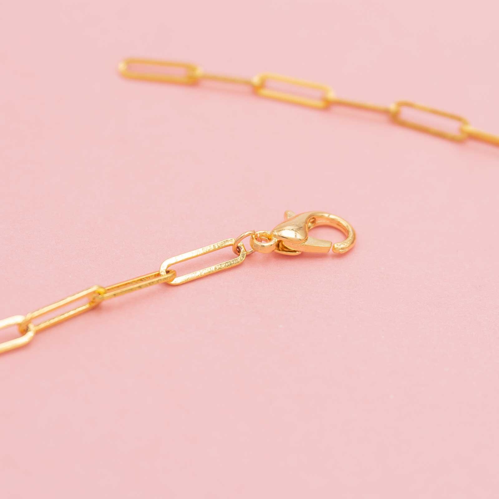 grobe goldfarbene Paperclipkette mit angebrachtem Karabiner in goldfarben