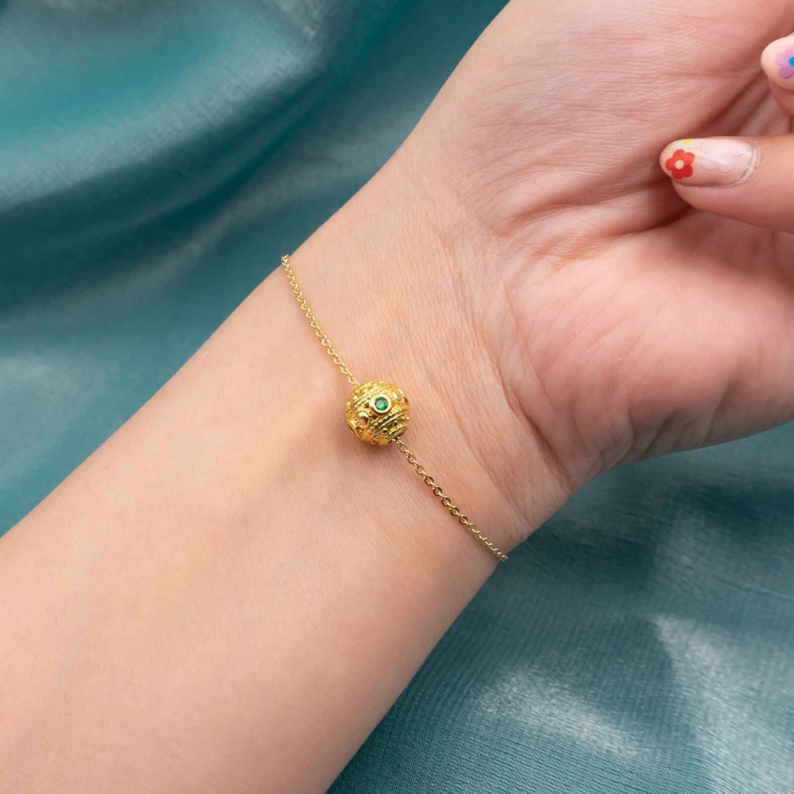 Armband bestehend aus einer feiner Gliederkette und goldfarbener Großlochperle 