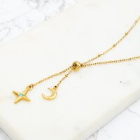 Feine goldfarbene Y-Kette auf einer Marmorplatte, die...