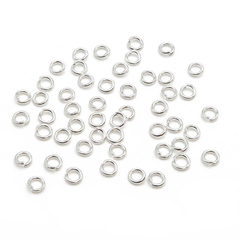 Freisteller mit zahlreichen offenen Biegeringen aus 304 Edelstahl in silberfarbener Beschichtung, lose auf weißem Hintergrund verteilt. Die runden Ringe mit 5 mm Außendurchmesser zeigen den glänzenden Silberton der Verkaufseinheit.