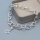 Bastelbeispiel: das silberfarbene Gliederarmband liegt an einer grauen Schmuckschale, vorn der Knebelverschluss mit Steg und Kugelenden, am Bandende hängt ein offener Sternanhänger als Gestaltungsbeispiel.