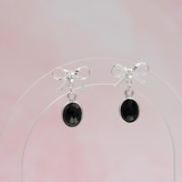 Ein Paar Ohrstecker in Schleifenform mit ovalem schwarzem...