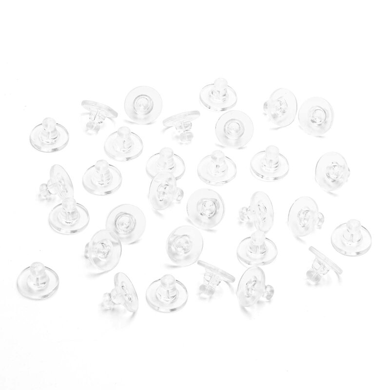 Viele transparente Ohrstopper aus Silikon locker auf weißem Untergrund verteilt, Schrägansicht. Gut zu erkennen sind die flache runde Scheibe und der aufgesetzte Kegel mit der Durchführung für den Steckerstift.