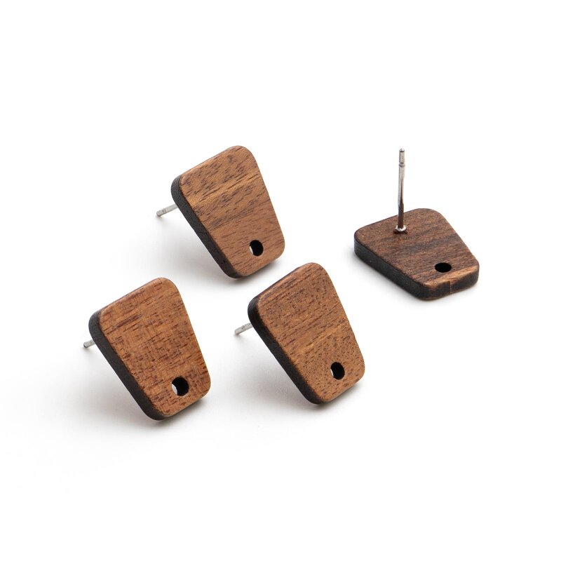 Vier Ohrstecker aus Walnussholz in Trapezform auf weißem Hintergrund, drei mit der Holzseite nach oben, einer aufgestellt mit Blick auf den platinfarbenen Edelstahl-Pin und das Fädelloch am unteren Rand.