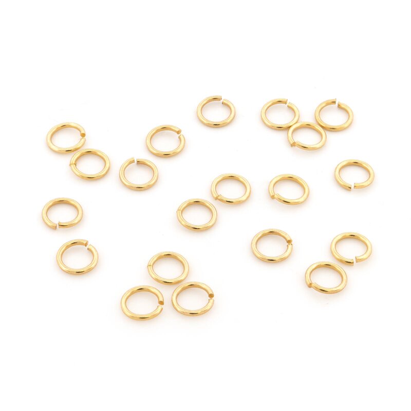 Offene Biegeringe aus Messing mit 24K Goldbeschichtung, von oben fotografiert und lose auf weißem Hintergrund verteilt, an jedem Ring ist die schmale Öffnung zu sehen