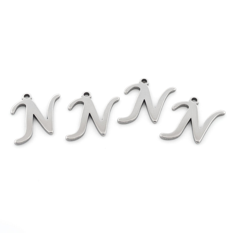 Vier Anhänger Buchstabe N in Schreibschrift aus platinfarbenem Edelstahl nebeneinander auf weißem Grund, jeder mit einem kleinen Loch zum Einhängen, die komplette Verkaufseinheit im Set.