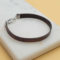 Armband aus dunkelbraunem flachem Lederband auf einer...
