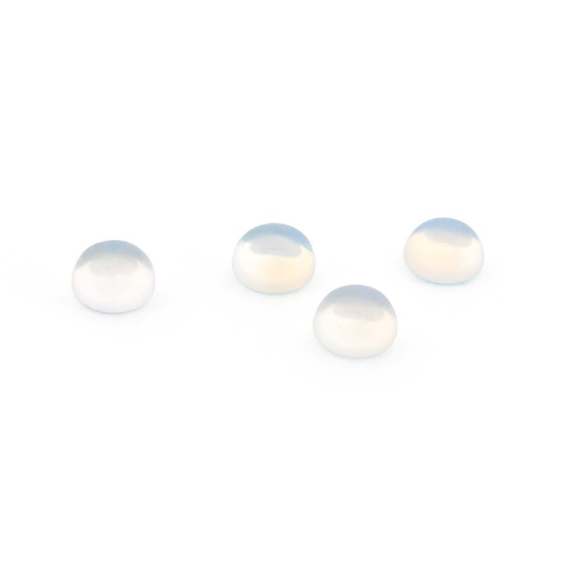Vier runde Opalite Cabochons auf weißem Hintergrund, halbrund gewölbt und milchig durchscheinend mit zartem bläulichem Schimmer an der Oberseite, schräg von oben fotografiert.