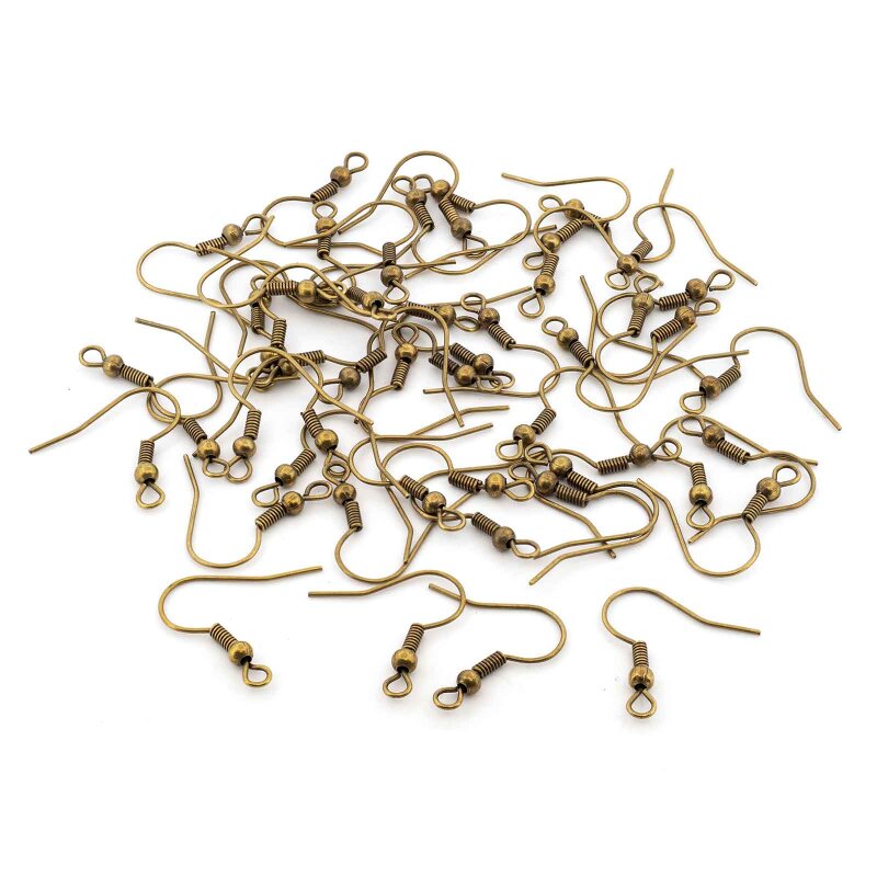 Rund 50 Ohrhaken in antik bronzefarbenem Finish als loser Haufen auf weißem Grund, jeder Haken trägt eine kleine Kugel zwischen Spiralwicklung und Öse.